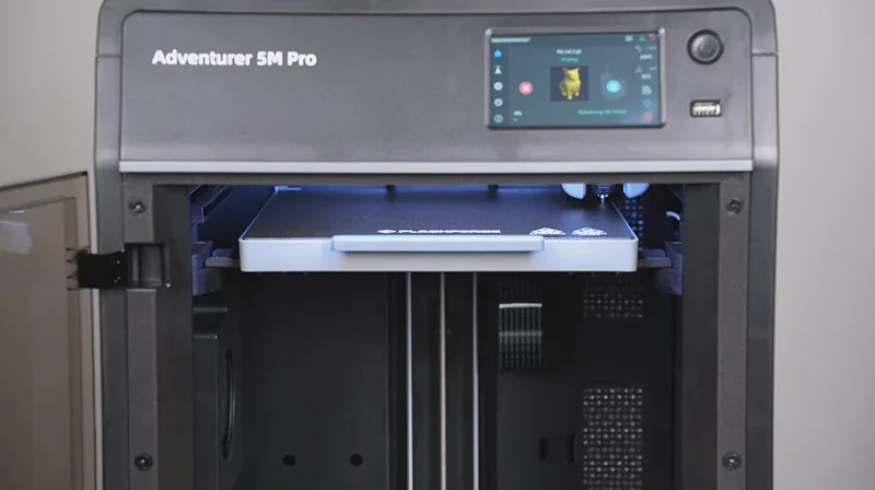 Flashforge Adventurer 5M Pro 3D printer with touch screen and open chamber, showcasing printing platform, branded logo visible.
