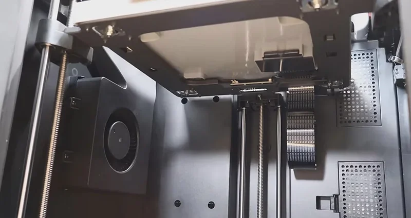 Flashforge Adventurer 5M Pro interior view showing precise mechanical components, belts, and fan designed for 3D printing.