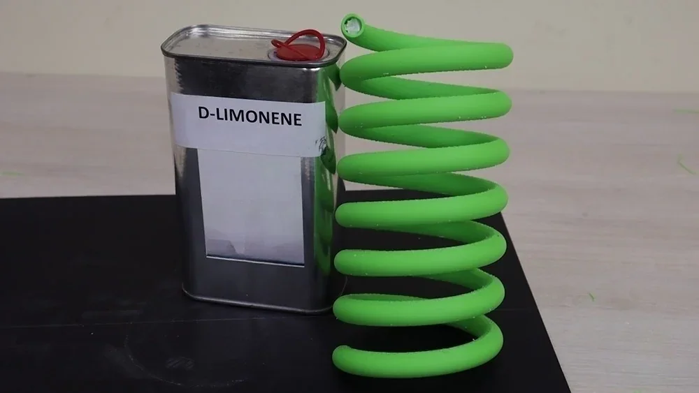 Green 3D-printed coil next to D-Limonene canister on a table, created using Flashforge Creator 4.