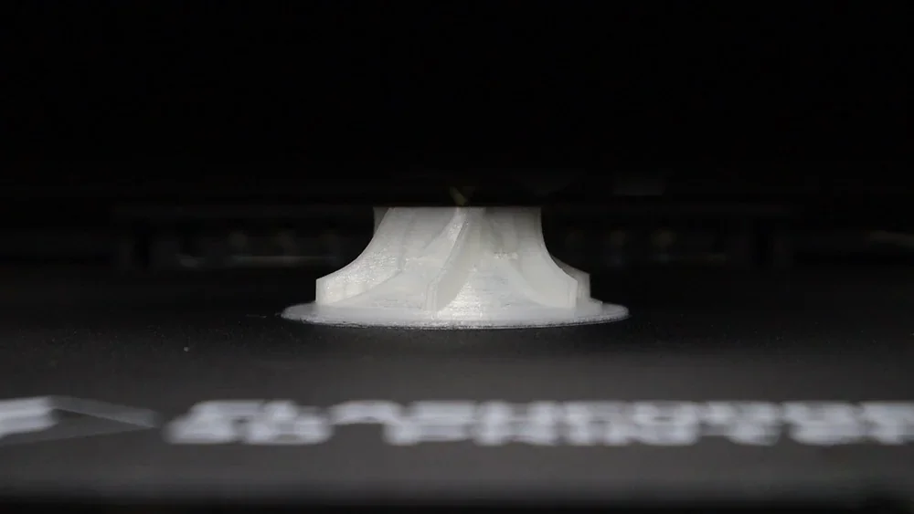 3D printed object by Flashforge Creator 4 on a black platform, partial view of branding text visible.