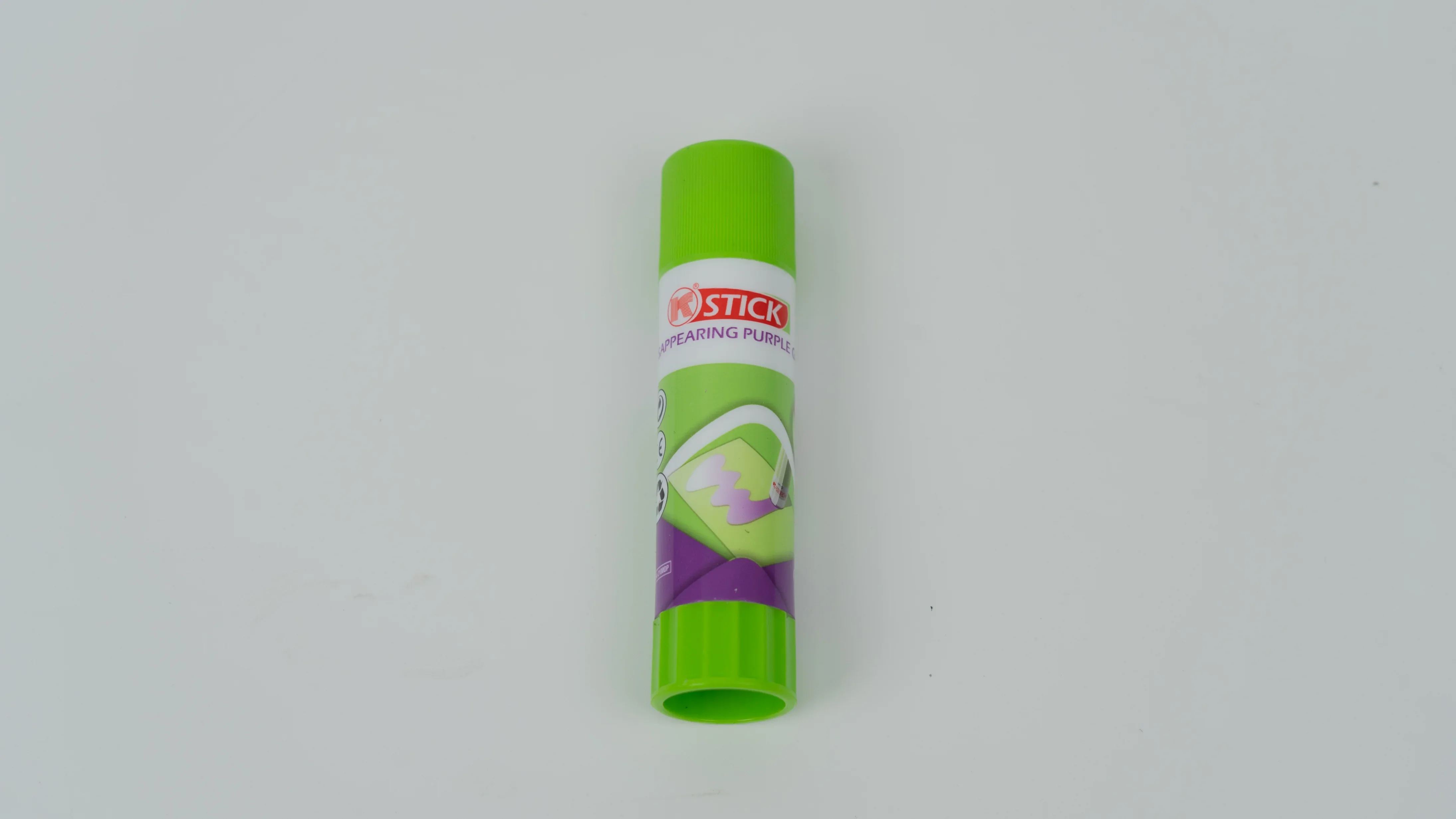 Green disappearing purple glue stick on white background with label branding.