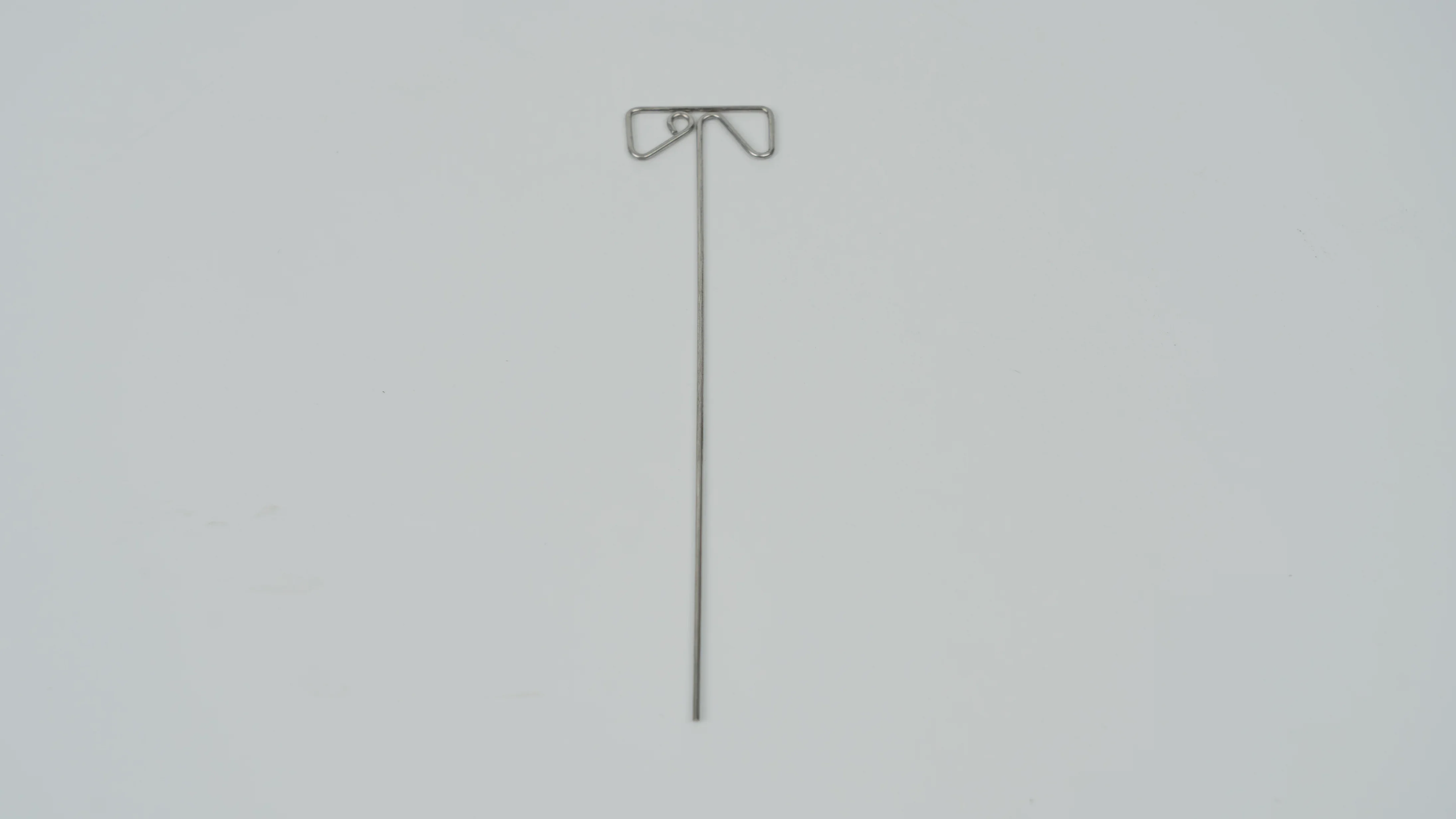A gray metal stirring rod with a unique end design, typically used for machinery, on a plain white background.