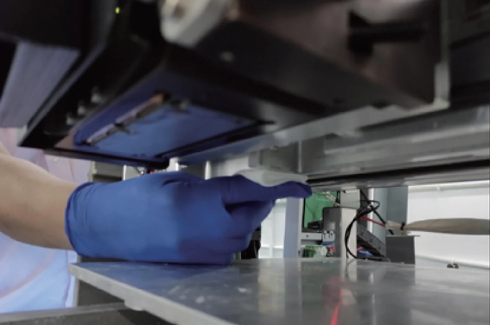 Flashforge WaxJet 400 in use, showing gloved hand removing 3D-printed part from printer, close-up view of machine with metal and plastic components.