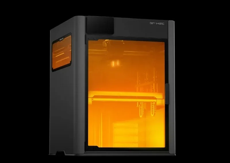 Bambu Lab H2C 3D printer with a transparent orange chamber showcasing internal components, designed for high-precision part production.