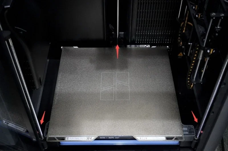 Bambu 3D printer interior with metal print bed, showing calibration patterns and mechanical components, showcasing h2c Bambu's high precision capabilities.
