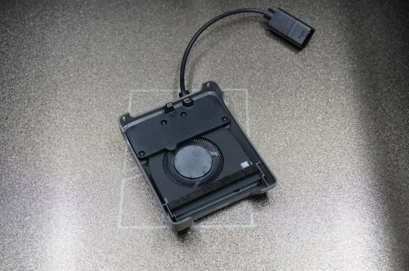 H2c Bambu 3D-printed external fan case with attached cable on a metallic surface, showcasing cooling component.