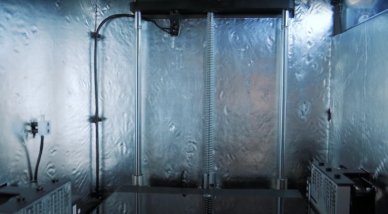 Intamsys Funmat HT 3D printer interior showing metal rods, wires, and components, showcasing the sturdy build and technical design.