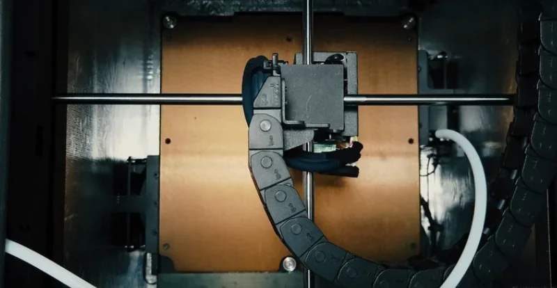 Intamsys Funmat HT 3D printer interior with nozzle, extruder, and cable chain, highlighting precision components for high-performance 3D printing.