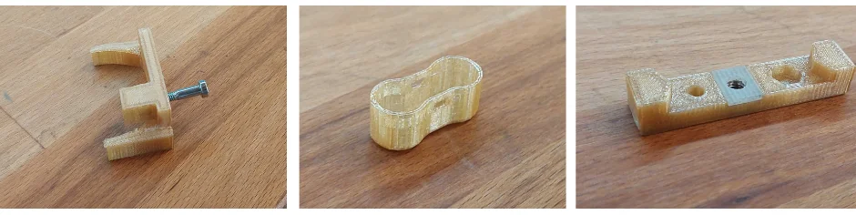 Three 3D-printed parts on wood, showcasing intricate designs produced by the Intamsys Funmat HT.