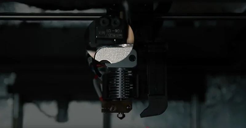 Intamsys Funmat HT 3D printer nozzle close-up in dim light, showing extruder detail and wiring, highlighting high-quality, precise parts creation.