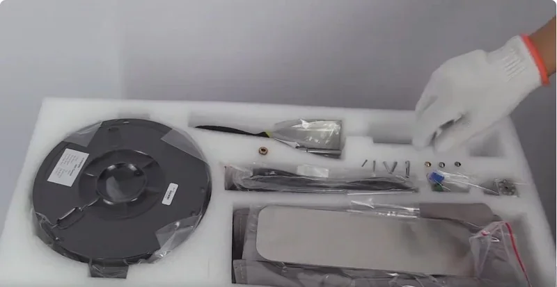 intamsys funmat ht accessories and filament spool in foam packaging, hand wearing glove.