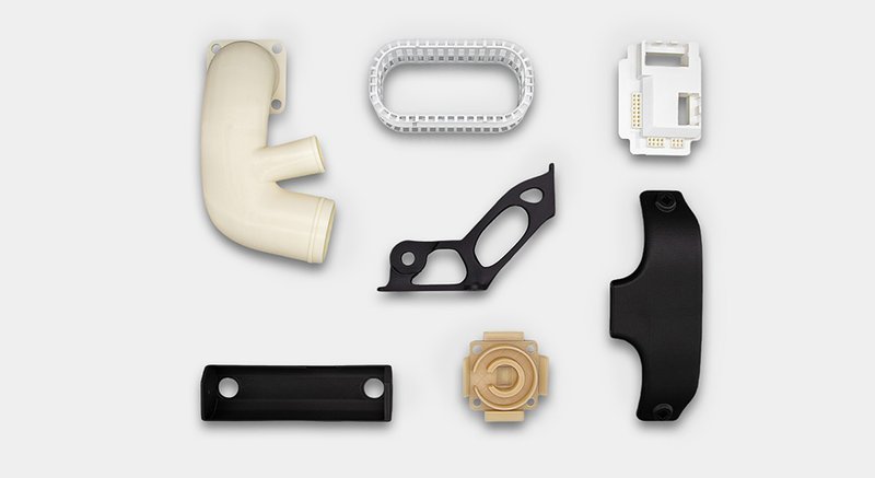 Displayed are various parts created by the INTAMSYS FUNMAT PRO 310 NEO 3D printer. The selection includes complex geometries and different materials, illustrating the printer's capability to handle diverse applications. Parts include a curved pipe, a mesh-like frame, and precision-engineered components, demonstrating the printer’s versatility and precision in producing functional prototypes and end-use products.
