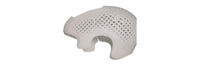 A white, perforated 3D printed structure created by the intamsys funmat pro 310. The object features a curved design with numerous small holes, resembling a lightweight shell or casing. The material appears smooth and uniform.