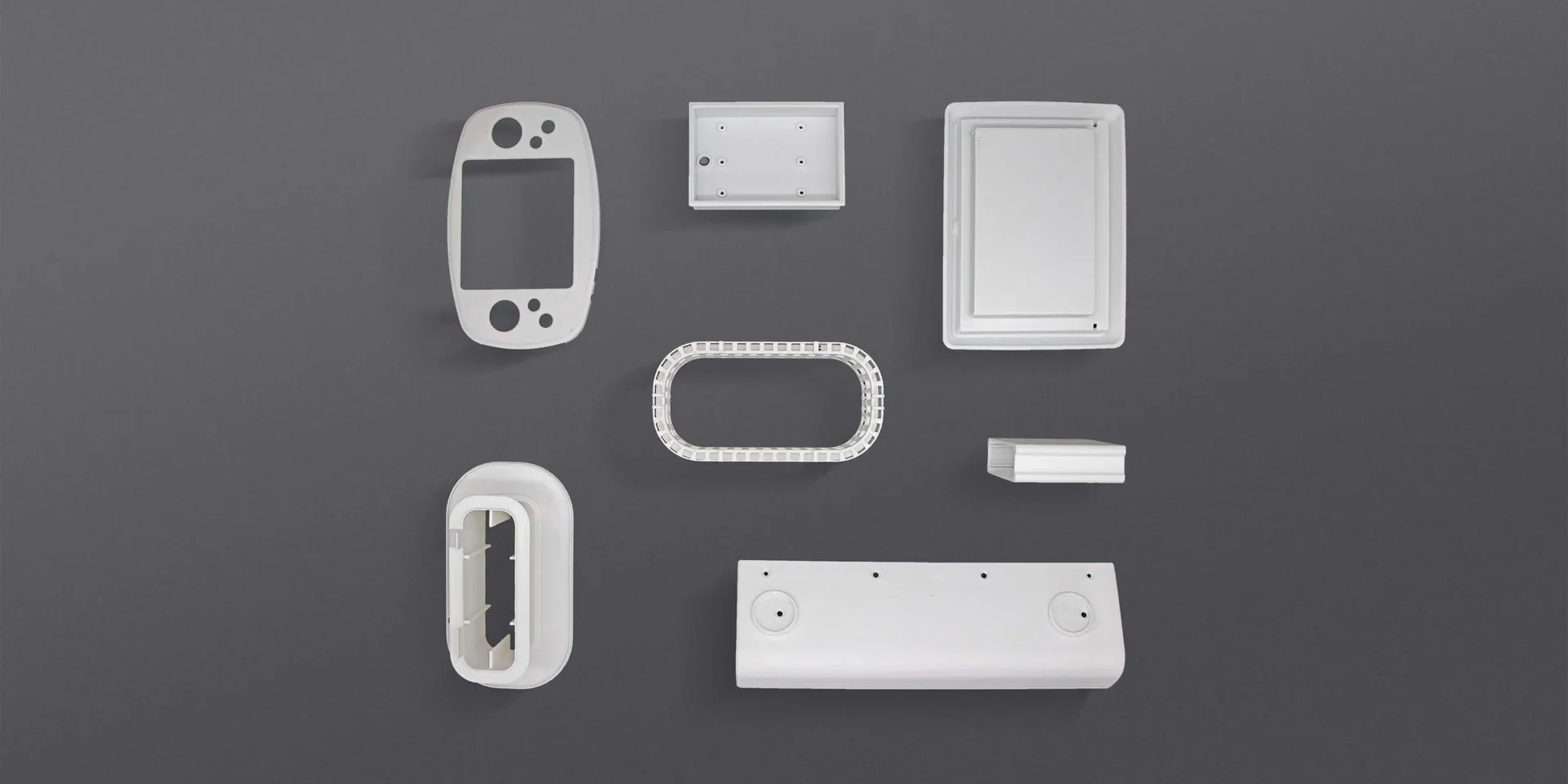 Various white 3D-printed parts arranged on a gray background, highlighting the capabilities of the Intamsys Funmat Pro 310 printer.