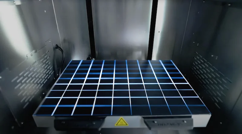 Intamsys Funmat Pro 310 3D printer interior with grid plate, ready for advanced material printing, set in a sleek, metallic enclosure.