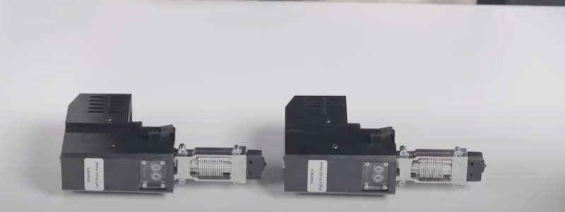Two extruder modules designed for the Intamsys Funmat Pro 310 are shown on a white surface. The modules are compact and feature a robust metal build with visible heat sink components, indicative of their precision engineering. Labels on the modules identify them as parts specific to the Pro 310, highlighting their compatibility and functionality specifics.