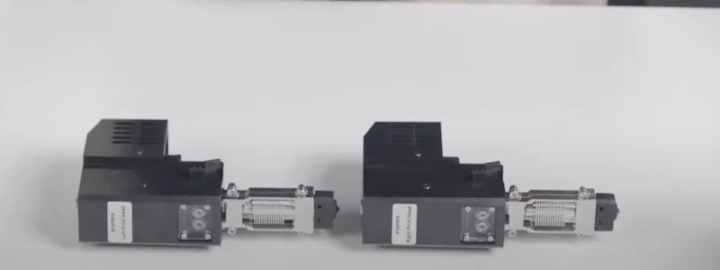 Two black and silver 3D printer extruders designed by INTAMSYS Funmat Pro 310 on a white surface, showcasing detailed components.