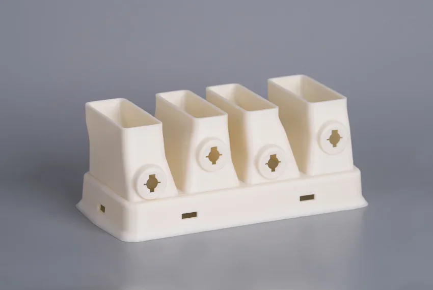 White plastic component with four rectangular sockets made by intamsys funmat pro 310, showcasing precision and material detail on a gray background.