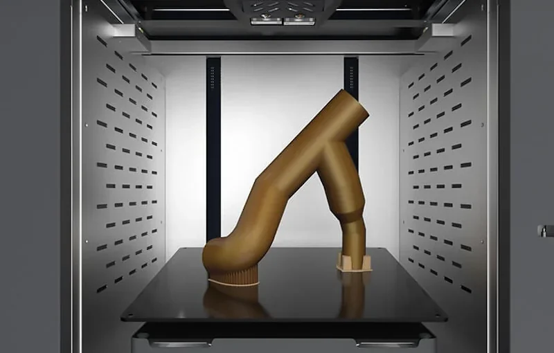 Intamsys Funmat Pro 410 printing a complex brown 3D part in its build chamber, showcasing advanced extrusion capabilities and industrial design features.