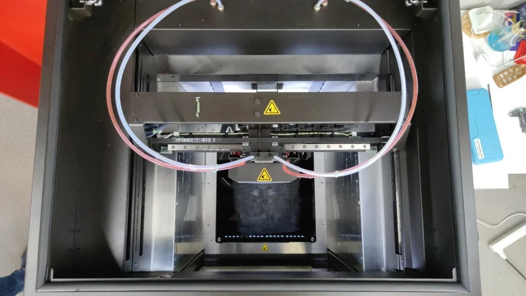 Intamsys Funmat Pro 410 3D printer interior view, showcasing dual filament tubes and a build chamber for creating samples or parts.