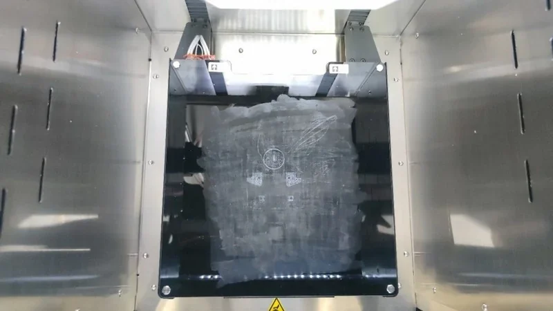 Intamsys Funmat Pro 410 3D printer interior with metallic surfaces and build platform, showcasing precision-engineered parts, likely produced by the machine.