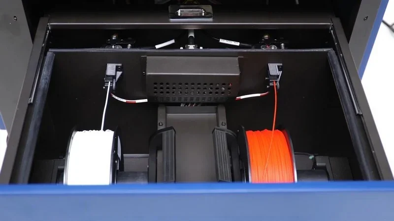 intamsys funmat pro 410 filament compartment showing two spools, white and orange, neatly fitted inside the printer's interior for 3D printing.