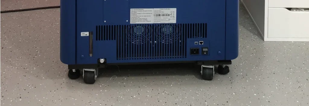 Intamsys Funmat Pro 410 on wheels, showing its back panel, ports, and ventilation on a speckled floor, highlighting its mobility and technical features.