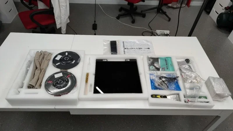 intamsys funmat pro 410 packaging with 3D printer parts and accessories on a white table, including filament spools, tools, and instructions.