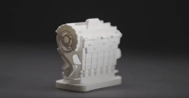 3D-printed white gear model on dark background, showcasing detail and precision, created by Intamsys Funmat Pro 610 HT printer.