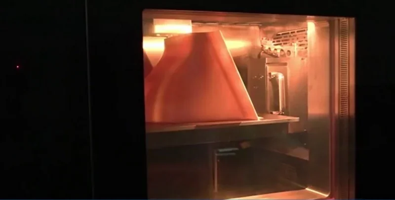 Intamsys Funmat Pro 610 HT printing a large, cone-shaped part in a lit chamber, showcasing its advanced 3D printing capabilities.