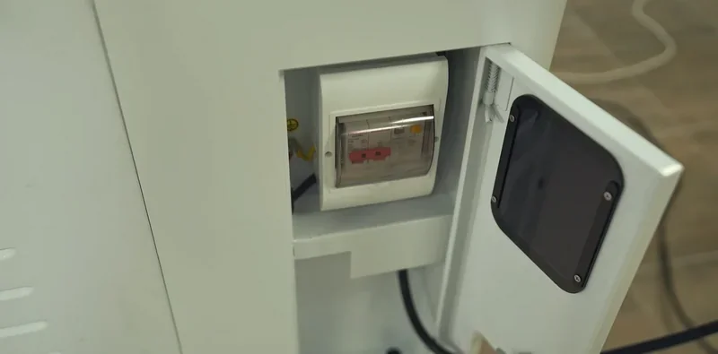 Mingda md-1000d internal view showing electrical enclosure with open door, showcasing control panel; industrial setting with visible wiring.