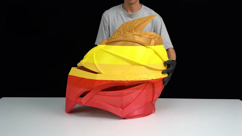 Mingda MD-1000D 3D-printed multicolored helmet held by a person wearing gloves, showcasing intricate design and large scale.