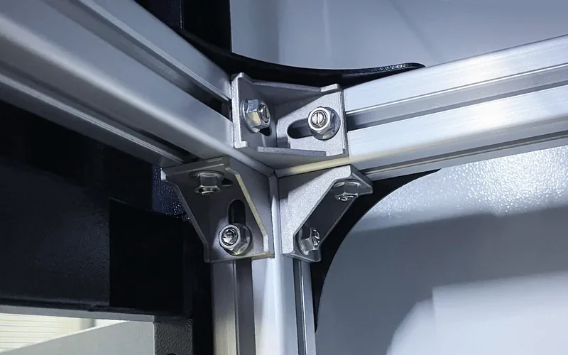 Mingda MD-1000D 3D printer detail showing metallic corner bracket and structural supports within its industrial design.