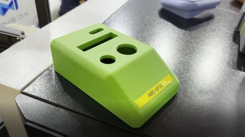 Bright green 3D-printed part by Mingda MD-400D on display table, showcasing precision and detail. Marked "ABS-GF25%".