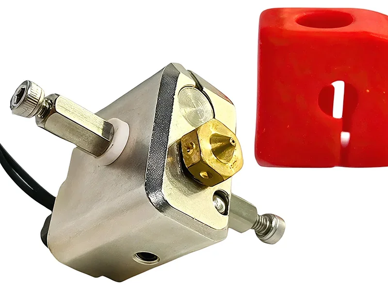 3D printer Modix Big 120X component featuring a metallic nozzle and a red cover part for precision printing tasks.