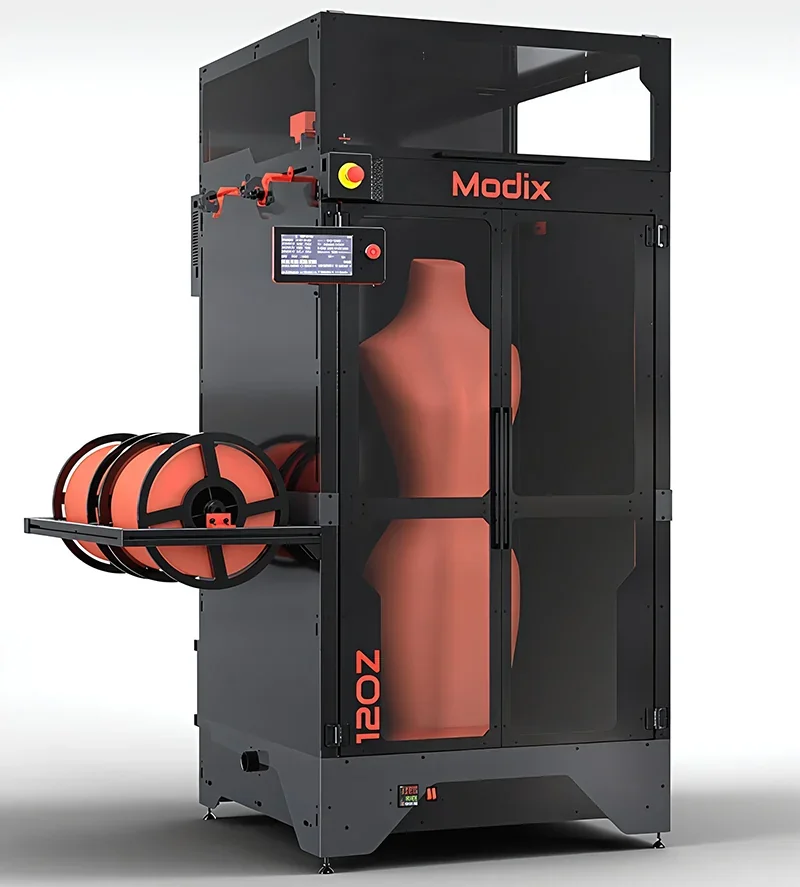 Modix Big 120Z 3D printer features a large chamber with orange filament spools and clear door, showcasing its capacity to print mannequin-sized objects.