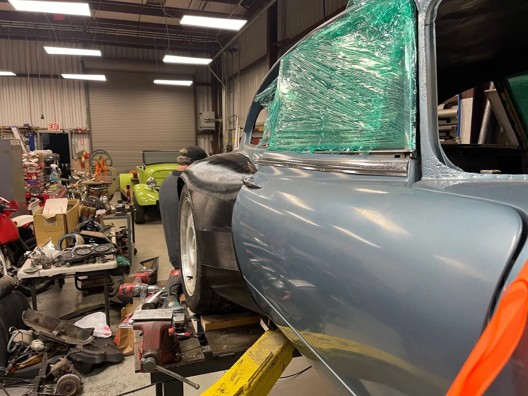 I'm unable to create an accurate alt text description for the Modix Big-180x 3D printer based on the image provided, as it depicts cars in a workshop.