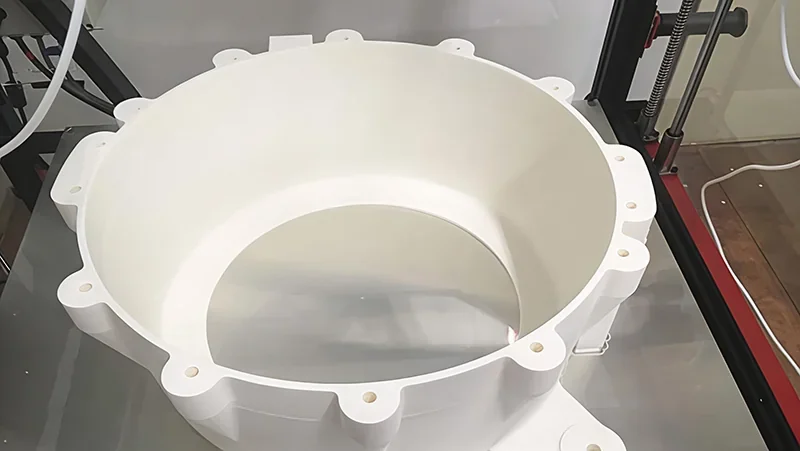 Large white 3D-printed part created by Modix Big-180x, showcasing intricate detailing within the printer's frame, highlighting its precision.