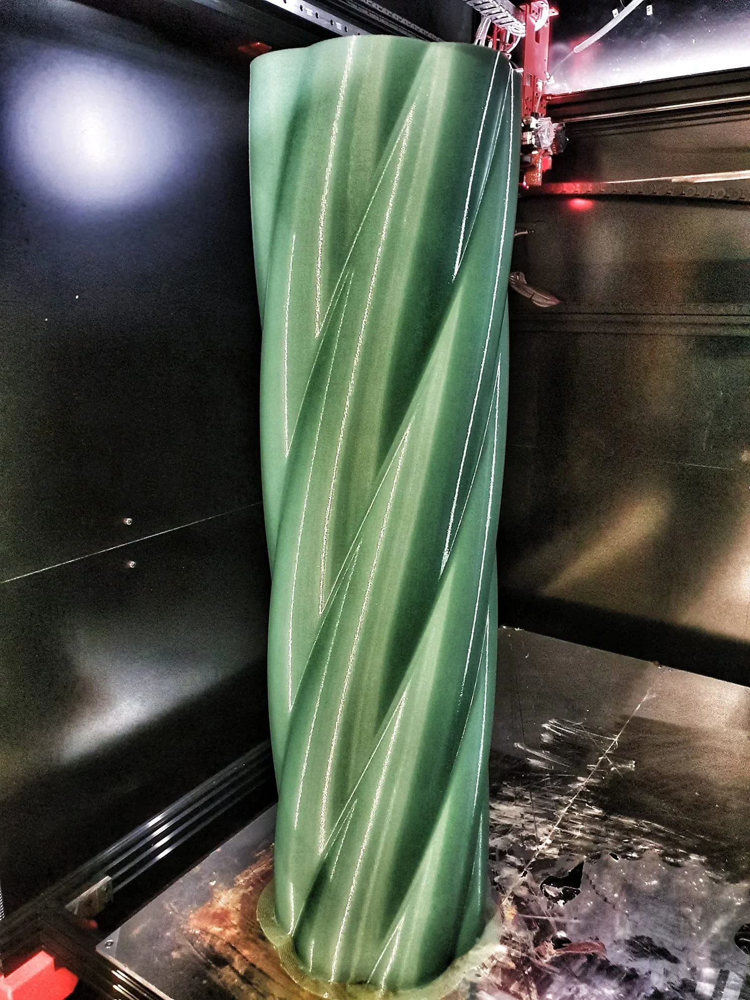 Modix Big Meter 3D printer producing a large green spiral-shaped object, showcasing its high-capacity printing capabilities.