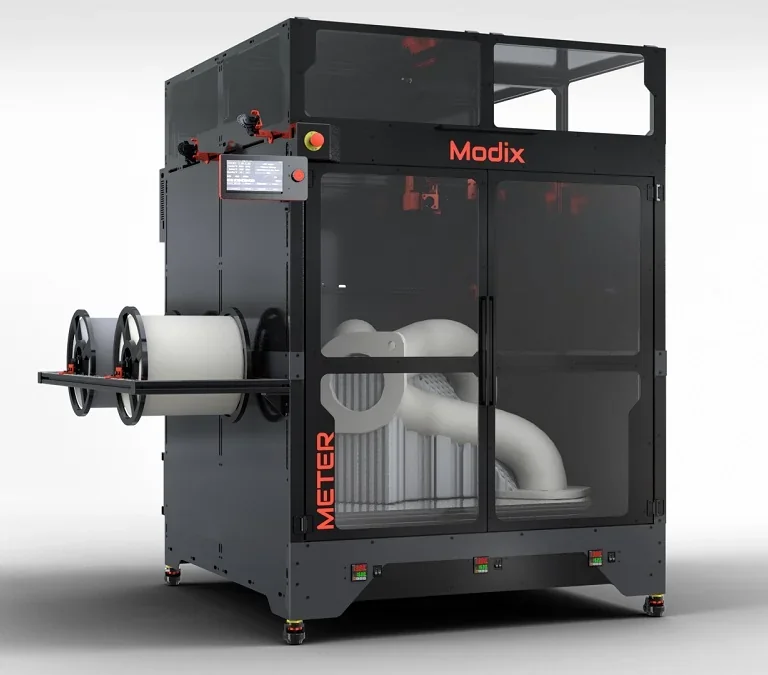 Modix Big Meter 3D printer with transparent casing, large filament spools, and a partially printed part inside, showcasing industrial design.