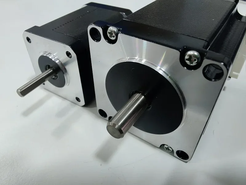 Stepper motors for modix everest 3D printer on a white surface, showcasing metal shafts and mounting plates.