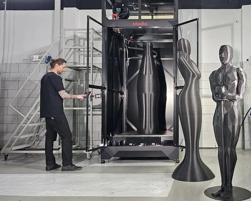 Modix Everest 3D printer producing large-scale geometric figures in an industrial setting, technician present.