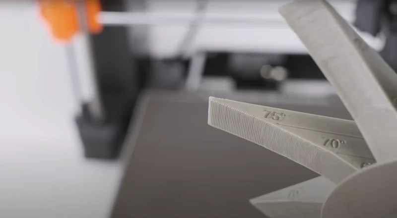 Original Prusa MK4S 3D Printer Kit with a sample fan model labeled with angles, showcasing detailed printing capabilities in a workshop setting.