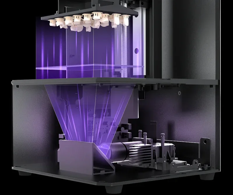 Phrozen Lumii DLP printer showcases internal components with purple light, highlighting 3D printing samples created by the machine.