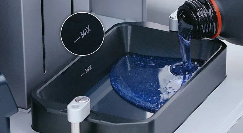 Phrozen Sonic CS+ 3D printer with blue resin being poured into the vat, marked with max level indicator, emphasizing precision and efficiency in use.