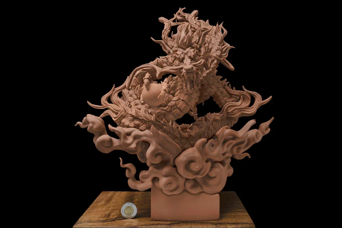 Detailed dragon sculpture printed by Phrozen Sonic Mega 8K on a wooden surface with a coin beside it for scale, showcasing intricate design and precision.