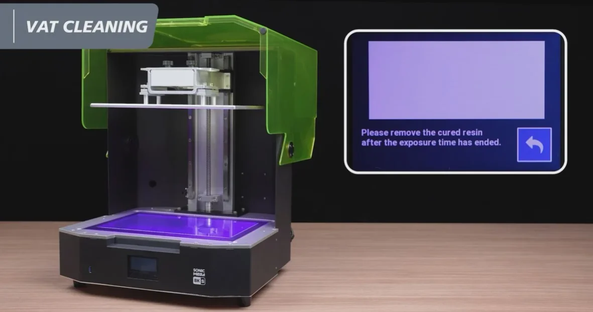Phrozen Sonic Mega 8K 3D printer with open green-tinted lid showing printing area, screen instructs to remove cured resin after exposure.