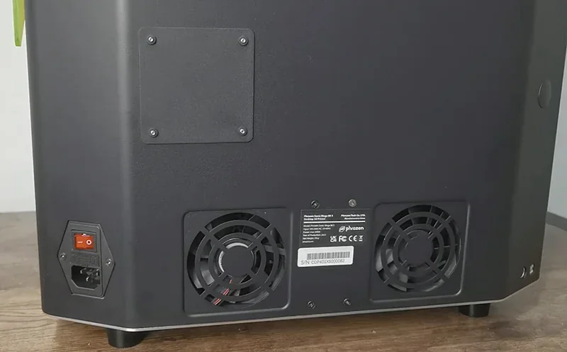 Back of Phrozen Sonic Mega 8K 3D printer with cooling fans, power switch, and branding on a wooden surface.