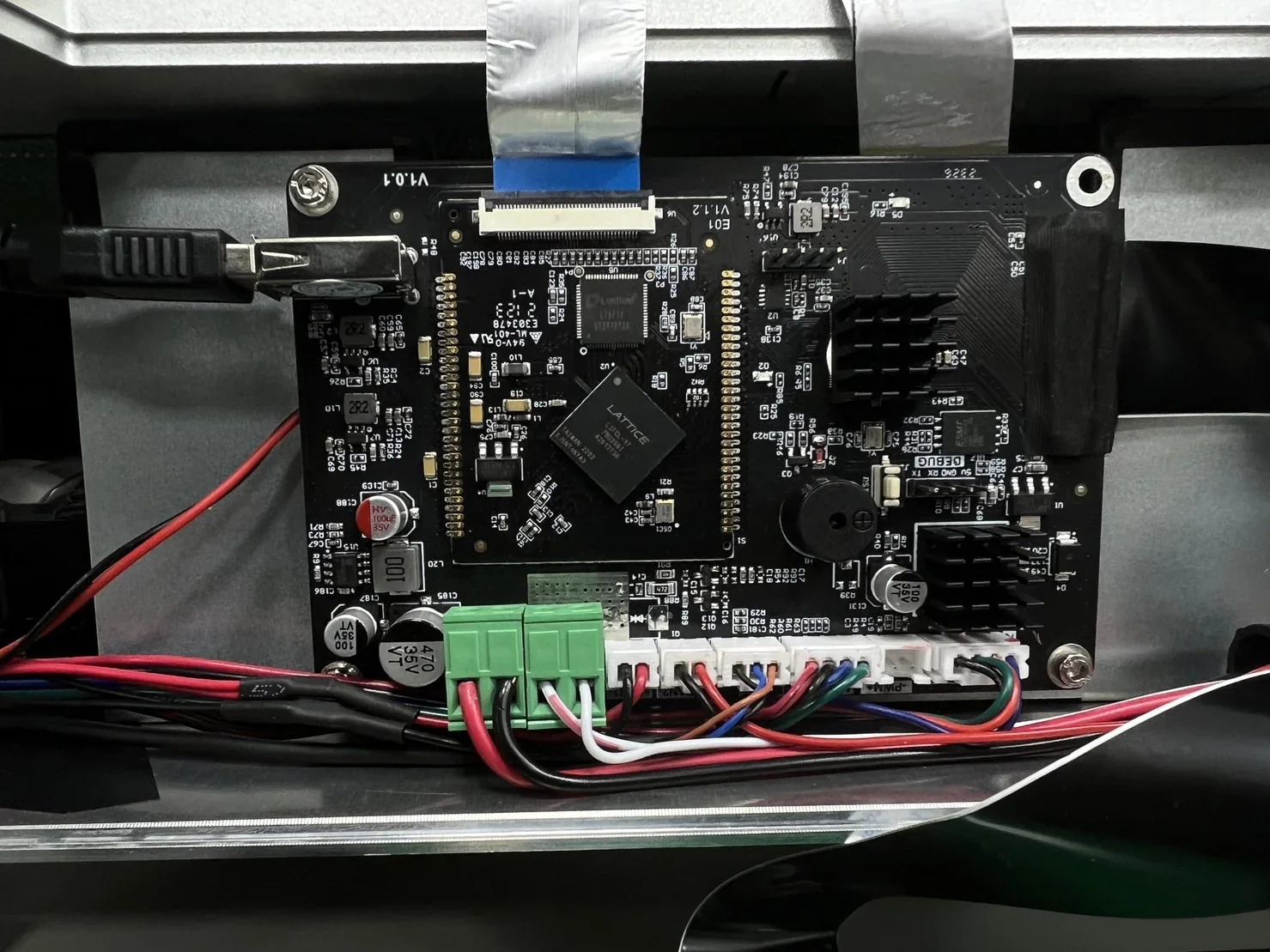 Close-up of Phrozen Sonic Mega 8K motherboard with wires and connectors inside the printer; detailed circuitry visible.