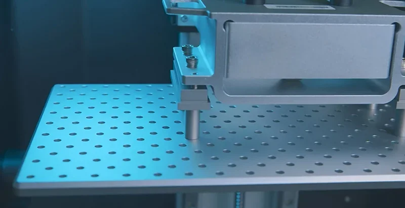 Phrozen Sonic Mega 8K build plate with perforated metal surface, viewed in close-up, detailed structure visible, showcasing part of its 3D printing mechanism.